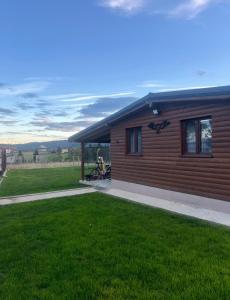 een huis met een groen gazon ervoor bij Cabana Nys Escape in Bălceşti