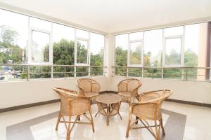 バンダーラウェラにあるHotel Lion Innの窓際に椅子3脚とテーブルが備わる部屋