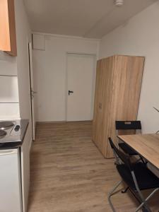 een lege kamer met een tafel en een deur bij CityCube Apartment in München +5 foto's