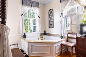 een badkamer met een bad en 2 ramen bij Miss Murphy's Bed and Breakfast in Galena