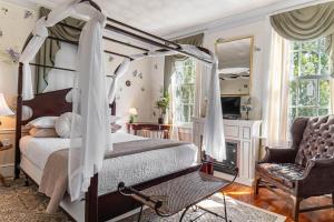 een slaapkamer met een hemelbed en een stoel bij Miss Murphy's Bed and Breakfast in Galena