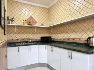 Una cocina con gabinetes blancos y una encimera negra. en Chic & Elegant Stay in Central Rabat, en Rabat 18 fotos más