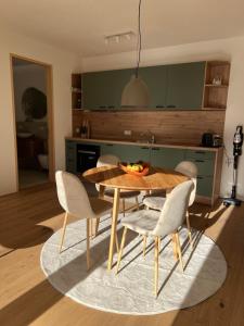 una cucina con tavolo e sedie in legno di Apartment Fidelia a Vandans