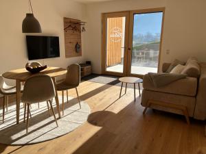 un soggiorno con un divano, un tavolo e delle sedie di Apartment Fidelia a Vandans