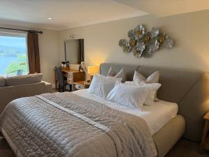 a bedroom with a bed with a couch and a window at Beech Hill Hotel & Spa in Windermere