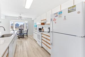 uma cozinha com armários brancos e uma geladeira branca em CAC-14B - Oyster em Buxton