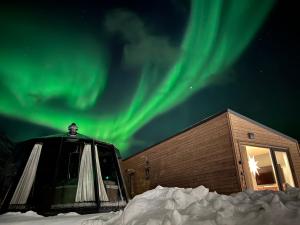 an igloo with the aurora in the sky at Alpan Apartments, Lyngenfjord in Olderdalen