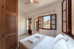a bedroom with a white bed and a window at Merry del Mare in Meyisti