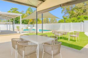 un patio con mesas, sillas y sombrillas en Yarrawonga Walk Everywhere by Ready Set Stay, en Yarrawonga