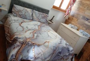 una camera da letto con un letto decorato con un motivo di montagna di Casa Lazer a Tonadico