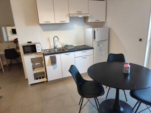 a kitchen with a table and chairs and a kitchen with a sink at Crystal Apartment Umag in Umag