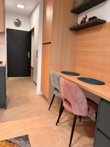 a kitchen with a wooden table and two chairs at Apartmán nad Dolným Kubínom in Dolný Kubín