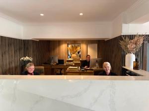 Dos mujeres y un hombre en el vestíbulo de un hotel. en Beech Hill Hotel & Spa, en Windermere