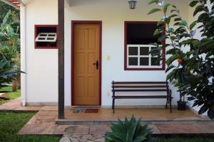 una panchina di fronte a una casa con una porta di Pousada da Serrinha a Mariana