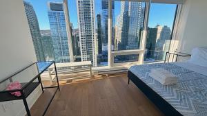 une chambre avec un lit et une grande fenêtre dans l'établissement Panoramic Horizon Condo - Downtown Montreal with Pool and Parking, à Montréal 17 autres photos