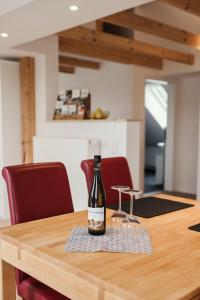 een fles wijn bovenop een houten tafel bij Ferienwohnung Habichthorst in Naumburg