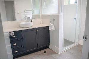 a bathroom with a sink and a shower at Balneaire 13 in Albany +14 photos