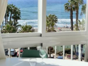 a view of the beach from a room with a window at Wake up to the Oceanfront Panoramic 180º Beachview Torrox-Costa Ruselo R408 ONLY ADULTS in Torrox Costa