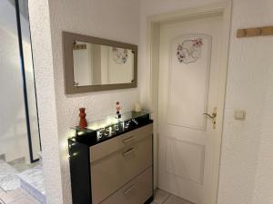 a bathroom with a sink and a mirror next to a door at Ferienwohnung Nidderau Komfort in Nidderau +29 photos