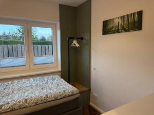 a bedroom with a bed next to a window at Fewo Voßbarg ünnen in Rastede