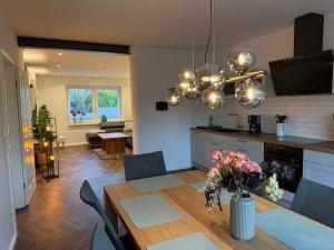 a kitchen and living room with a table and a dining room at Fewo Voßbarg ünnen in Rastede