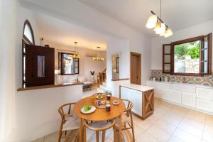 a kitchen and dining room with a table and chairs at Merry del Mare in Meyisti