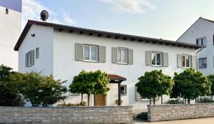 een wit huis met bomen ervoor bij Das Kornburg-Quartier in Neurenberg