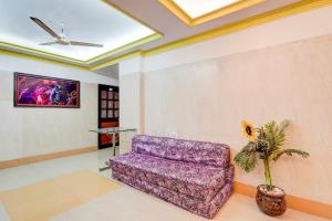 un sofá púrpura en una sala de estar con techo en SPOT ON Dn Hotel, en Gorwa
