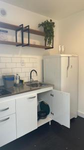 een keuken met een spoelbak en een koelkast bij Box 01 a 950 mt do mar, ar- condicionado, TV smart, cozinha privativa in Itapema