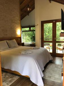 a bedroom with a white bed and a large window at Afha 48 in Monte Verde