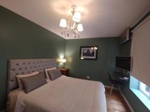 a bedroom with a large bed and a chandelier at Maitre Hotel Boutique in Buenos Aires