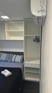 - une chambre avec un lit et un placard dans l'établissement Box 02 a 950 mt do mar, ar- condicionado, TV smart, cozinha privativa, à Itapema