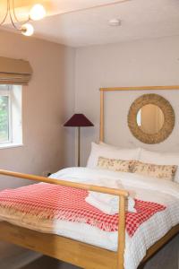 ein Schlafzimmer mit einem Bett mit Holzrahmen und einem Spiegel in der Unterkunft Calm Private Apartment in Ashford Ideal to Work, Rest Explore in Smeeth