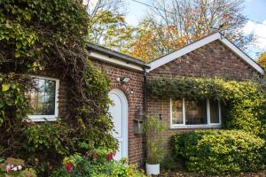 ein Backsteinhaus mit weißer Tür und Efeu in der Unterkunft Calm Private Apartment in Ashford Ideal to Work, Rest Explore in Smeeth