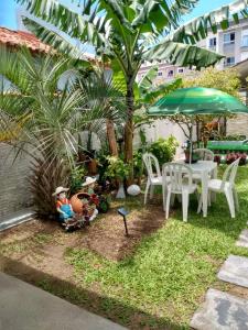 フロリアノポリスにあるCasa nos Ingleses - 1 quartoの庭園(テーブル、椅子、パラソル付)