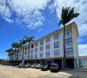 a large building with cars parked in a parking lot at City Studios Apartamentos Novos em Natal in Natal