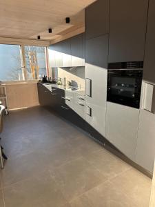 a kitchen with black and white cabinets and appliances at Silenen Chalet I Andermatt I Ski I Berg I Familie in Silenen