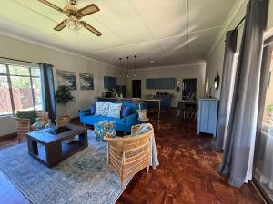 a living room with a blue couch and a table at Lilibeth guesthouse in Parys