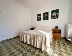 a bedroom with a bed and two pictures on the wall at Casa Felice 1910 in Introdacqua