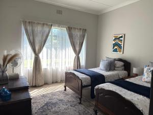 a bedroom with two beds and a window at Lilibeth guesthouse in Parys +40 photos