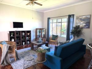 a living room with a blue couch and a tv at Lilibeth guesthouse in Parys