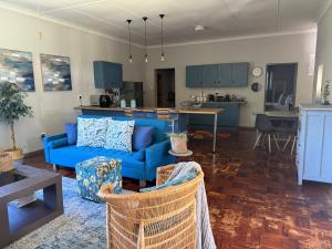 a living room with a blue couch and a kitchen at Lilibeth guesthouse in Parys