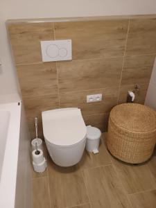 a bathroom with a white toilet and a basket at Apartmán Vail in Svoboda nad Úpou +16 photos