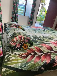 un lit avec une couette et des oreillers colorés dans l'établissement Punahere lodge Ohotu, à Rangiroa