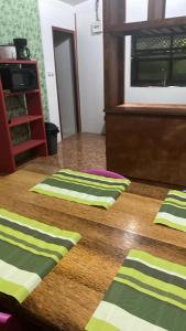 deux serviettes à rayures vertes et jaunes sur une table en bois dans l'établissement Punahere lodge Ohotu, à Rangiroa 14 autres photos