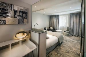 een hotelkamer met een bed en een bureau bij Mas de Guilles in Lourmarin