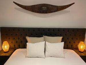 アントワープにあるCharming modern apartment in the heart of Antwerp with optional private parkingのベッド1台(白い枕、テーブルの上にランプ2つ付)