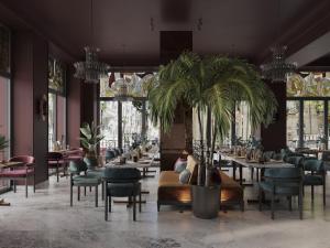 Un restaurante con mesas y sillas y una palmera. en Hotel Indigo Batumi - Old Town by IHG, en Batumi