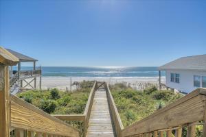 a wooden boardwalk leading to a beach with a house at Shore Bet in Surf City