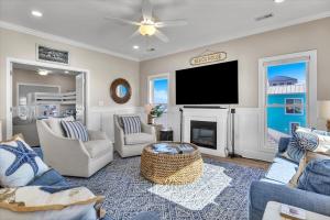 a living room with a flat screen tv and a fireplace at Shore Bet in Surf City +90 photos